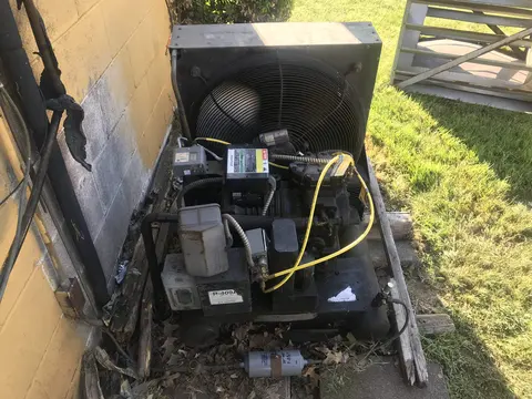 Open refrigeration condensing unit with wiring exposed during service