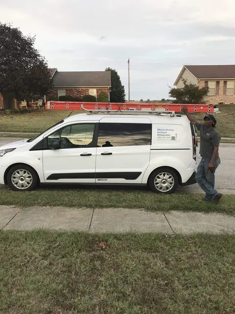 Technician standing beside a white Efficient HVACR service van
